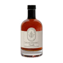 A clear glass bottle of Under The Bark Syrup Co Smoke Maple Syrup, labeled with a leaf illustration. This cold smoked syrup is crafted in Minnesota and ideal for cocktails.