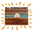 The Words With Boards Large Personalized Cutting Board (12.5" x 16") by Words with Boards, LLC features a handcrafted design with a name carved in bold letters, a green band labeled "Words With Boards," and yellow sunburst accents.