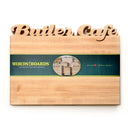 The Words With Boards Large Personalized Cutting Board (12.5" x 16") by Words with Boards, LLC features "Butler Cafe" cut out at the top and a center label with a green band and heart symbol.