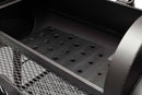 Close-up view of the interior of a Yoder Smokers Durango 20 Offset Smoker by Yoder Smokers, featuring a perforated metal plate at the bottom and a mesh shelf on the side.