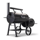 The Yoder Smokers Loaded Wichita Offset Smoker is a black, barrel-style grill with a side firebox, large wheels, front shelf, and upright chimney—perfect for outdoor barbecue cooking.