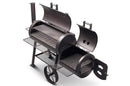 The Yoder Smokers Loaded Wichita Offset Smoker by Yoder Smokers is a black metal grill with dual chambers, open lids showing cooking grates. It features a chimney, large side wheels, and vented firebox door for classic American barbecue smoking.