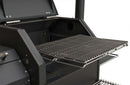 A close-up of the Yoder Smokers YS480S Competition Pellet Grill with Stainless Steel Shelves highlights its metal cooking grates, spacious grilling area, and durable black exterior.