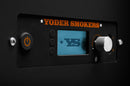 Close-up of the Yoder Smokers YS480S Competition Pellet Grill with Stainless Steel Shelves digital control panel, featuring an orange power button, "YS" display, and a large silver knob for direct-flame grilling adjustments.