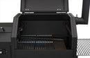 A close-up of an open Yoder Smokers YS480S Competition Pellet Grill with stainless steel shelves, showing empty metal grates, a right-side smoker box, and the lid open to reveal the interior ready for direct-flame grilling.