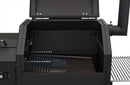 A close-up of the open Yoder Smokers YS480S Competition Pellet Grill with Stainless Steel Shelves shows interior components like the grilling grate, heat shield, and drip tray; control panel and chimney are visible for direct-flame grilling.