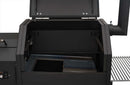 A close-up of an open Yoder Smokers YS480S Competition Pellet Grill with Stainless Steel Shelves, showing the empty cooking chamber and metal components inside, as well as the side and chimney of the grill.