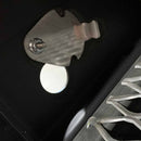 Close-up of a metal surface with a bolt, bracket, circular hole, and grated metallic structure—features of the Yoder Smokers YS480S Competition Pellet Grill with Stainless Steel Shelves by Yoder Smokers, designed for direct-flame grilling.