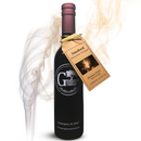 A bottle of Georgetown Olive Oil Co. Smoked Balsamic Vinegar from Georgetown Olive Oil Co., featuring a tag with product information and delicate wisps of smoke encircling the bottle, evoking the rich tradition of premium aged Modena-style balsamic vinegar.
