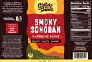 Chiles and Smoke’s Smoky Sonoran Barbecue Sauce comes in a 14.5 oz bottle showcasing bold “Smoky Sonoran” text and desert-inspired graphics, along with notes of Fruity • Tangy • Savory. The label highlights nutrition facts, ingredients, and serving suggestions—drawing inspiration from the vibrant flavors of the Sonoran Desert for perfect live fire cooking. Also available as part of the Chiles & Smoke Sonoran BBQ Starter Box.
