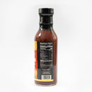 A glass bottle of Chiles & Smoke Smoky Sonoran BBQ Sauce by Chiles and Smoke, featuring a reddish-brown sauce and a black cap, is pictured. The back label displays nutrition facts, and the background is plain white.