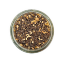 A glass jar of SALTOPIA Infused Sea Salts' Saltopia Smoked Alderwood, Grapefruit & Garlic Salt, featuring a mix of brown and beige granules, is viewed from above against a white background.