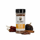 A bottle of B.T. Leigh’s Gluten-Free Taco Seasoning surrounded by two dried chili peppers, a round dried chili, a cinnamon stick, and cacao nibs.