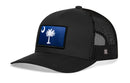The Haka Hat South Carolina Flag Trucker Hat features a black mesh design and a blue patch with the state's iconic crescent moon and palmetto tree on the front panel, combining comfort and style in a snapback by Haka Hat.