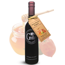 A bottle of Georgetown Olive Oil Co. Spicy Honey Pepper Balsamic, with a tag, is displayed in front of a blurred honey jar and habanero pepper—showcasing an expertly crafted blend of aged balsamic vinegar from Modena for a sweet and spicy finish.
