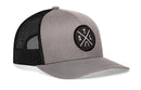 The Haka Hat St. Louis Trucker Hat is a gray-black snapback with a circular STL X embroidered patch on the front, featuring intersecting lines and white S, T, L, U letters.