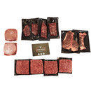 A selection of vacuum-sealed raw American beef strip steaks and ground beef patties from the Dude Food Kings Meat Box, arranged around a Dude Food business card on a white background.
