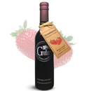A dark glass bottle of Georgetown Olive Oil Co. Strawberry Balsamic Vinegar from Modena, Italy, featuring a gold-tag label with a strawberry illustration, is displayed in front of a large strawberry image.