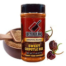 A bottle of Butcher BBQ Sweet Chipotle BBQ Seasoning by Butcher BBQ is pictured with brown sugar and whole dried chipotle peppers, emphasizing its smoky-sweet heat. The label shows a meat cleaver logo and bold yellow text.