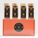 The Spice Wheel Sweet Baking 4 Pack Starter Kit by Spice Wheel features four glass jars of Allspice Powder, Cinnamon Powder, Clove Powder, and Ground Nutmeg, each topped with a wooden lid. Arranged on the vibrant orange Spice Wheel box adorned with its circular logo, this curated set includes aromatic allspice powder, rich cinnamon powder, and bold clove powder—perfect for elevating your sweet baking creations.