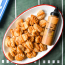 Chicken nuggets served on an oval plate, drizzled with Terrapin Ridge Farms Honey BBQ Aioli Squeeze, next to the Terrapin Ridge Farms sauce bottle, all set on a green surface resembling a football field.