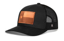The Haka Hat Texas Flag Trucker Hat Leather is a black mesh snapback featuring a curved brim and a rectangular brown leather patch with a star and block Texas flag design on the front panel by Haka Hat.