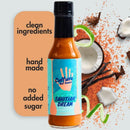 A bottle of Culture Hot Sauce Tahitian Dream by Culture Hot Sauce is displayed alongside coconut, vanilla, a green ribbon, and red spices. The side label highlights “Clean Ingredients,” “Hand Made,” and “No Added Sugar.” This tropical hot sauce blends the creamy sweetness of coconut with fragrant Tahitian vanilla to deliver a uniquely vibrant flavor—an elevated coconut lime hot sauce crafted for adventurous palates.