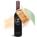 A dark wine bottle labeled "Georgetown Olive Oil Co." with a tan tag that reads "Tangerine Balsamic Vinegar" from Georgetown Olive Oil Co. stands in front of a large tangerine fruit and leaf, showcasing this balsamic vinegar crafted from aged Modena vinegar.