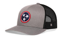 The Haka Hat Tennessee Flag Trucker Hat in gray and black features a circular patch with three white stars on blue with a red border, solid fabric front, black mesh back and sides, and an adjustable snapback.