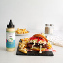 A beef, coleslaw, and red pepper sandwich with crinkle fries topped with Terrapin Ridge Farms Avo Zingy Garlic Aioli sits on a slate plate. Extra fries for dipping in the aioli, salt and pepper shakers, and a napkin are nearby.