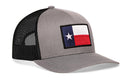 The Haka Hat Texas Flag Trucker Hat | Gray-Black TX Snapback features a Texas flag patch with a blue stripe, white star, and bold stripes on the front panel, all in a classic Haka Hat gray and black mesh snapback trucker style.