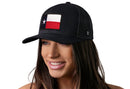 A woman with long brown hair smiles in a Haka Hat Texas Flag Trucker Hat | Black TX Snapback by Haka Hat, set against a white background.