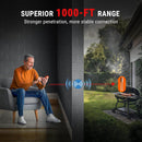 Man using a device with text about superior range, sitting indoors with outdoor scene of a grill. ThermoPro TempSpike 1000FT RF wireless meat thermometer with dual waterproof probes at DDR BBQ Supply