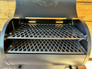 Two-tiered, metal diamond-patterned Pimp My Grill® Pro Series Slide-Out Rack System for Traeger Tailgater / Junior installed inside a pellet grill, featuring a slide-out rack system for dual-zone grilling.