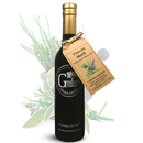 A dark glass bottle of Georgetown Olive Oil Co. Tuscan Herb Infused | High Polyphenols Extra Virgin Olive Oil, featuring a brown tag with herb illustrations and branded with Georgetown Olive Oil Co., set against a backdrop of fresh herbs.