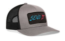 The Haka Hat Send It Trucker Hat by Haka Hat features a gray-black snapback design with a comfort-fit sweatband and a front rectangular patch embroidered with "SEND IT" in blue and red.