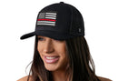 A woman smiles, wearing a Haka Hat Thin Red Line Trucker Hat—Black Fire Snapback with an American flag patch, honoring firefighters. The background is white.