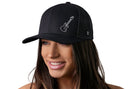 A smiling woman wears the Haka Hat Electric Bass Trucker Hat, a black snapback by Haka Hat featuring a white electric guitar outline on the front. The background is plain white.