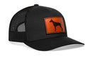 The Haka Hat Doberman Trucker Hat features a black mesh design and a brown leather patch with a dog silhouette on the front, by Haka Hat.