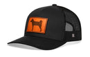 The Haka Hat Shiba Inu Trucker Hat is a black mesh snapback featuring an orange leather patch with a curled-tail dog silhouette on the front.
