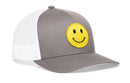 The Haka Hat Smiley Face Trucker Hat in gray and white features a large yellow embroidered emoji patch on the front panel and a comfort-fit sweatband for all-day wear.