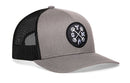 The Haka Hat GYM Trucker Hat is a gray and black mesh workout snapback from Haka Hat, featuring a comfort-fit closure and a round patch with white embroidered barbells and the letters G, Y, and M.