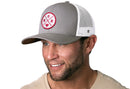 A man wears the Haka Hat Mom Trucker Hat, a gray-white snapback featuring a pink MOM patch with heart and a comfort-fit sweatband for all-day wear.