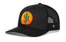 The Haka Hat Cactus Sunset Trucker Hat features a black mesh back and a round patch with a green cactus and orange sunset—ideal for a western vibe.