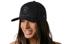 A smiling woman wears the Haka Hat Boy Dad Trucker Leather Hat, a black snapback by Haka Hat with a round leather patch reading "BOY DAD" and three stars, set against a plain white background.