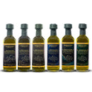 Six bottles from the Georgetown Olive Oil Co 6 Bottle Variety Pack | Ultra High Polyphenols Extra Virgin Olive Oil by Georgetown Olive Oil Co. are arranged side by side, each showcasing a unique label color and origin, along with their distinct varieties and scientific diagrams on the front. This variety pack highlights Mediterranean flavors and includes an Ultra High Polyphenols Extra Virgin Olive Oil, perfect for those seeking exceptional taste and health benefits.