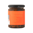 A glass jar with a black lid contains Taycte Famiglia Crispino Sun-Dried Tomato Antipasto — Italian Marinated in Olive Oil. The orange label displays ingredients and nutrition details in multiple languages, visible from the back.