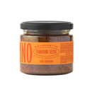 A glass jar with a black lid containing Taycte Crispino Bruschetta Pomodori Secchi — Calabrian Sun-Dried Tomato Spread from the Taycte brand, labeled in Italian with an orange label. This vegan, gluten-free spread features sun-dried tomatoes in extra virgin olive oil.