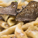 Close-up of pasta topped with thinly sliced Taycte Black Truffle Carpaccio from Taycte, showcasing the creamy sauce and the detailed texture of Tuber Aestivum truffles.