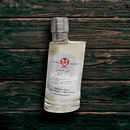 A bottle of Acetaia Malpighi Prelibato White Balsamic Vinegar — Premium Italian Condimento Bianco by Taycte, with a silver cap, rests at an angle on dark wood. Its label displays red and black text with a crest.